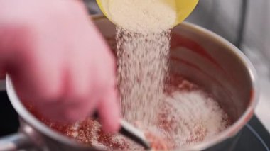 Şekerci çilek ya da ahududu püresine bento keki için şeker ekler. Ev yapımı marmelat, böğürtlen ziyafeti, hamur işi için reçel sosu. Yüksek kalite 4k görüntü