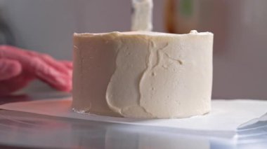 Pasta şefi pasta kenarlarını kremayla düzeltiyor. Şekerci spatulayla çalışıyor. Pasta dekorasyonu. Yüksek kalite 4k görüntü