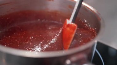 Profesyonel bir pastacı çilek ya da ahududu sosu pişirir, bento keki için doldurur. Ev yapımı marmelat, böğürtlen ziyafeti, hamur işi için reçel sosu. Yüksek kalite 4k görüntü