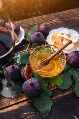 Peynir tabağıyla peynirli peynir, sağlıklı organik incir, bal ve üzüm. Kırmızı şarap kadehi, aperatif seti. Mevsimlik meyveler. Yüksek kalite fotoğraf