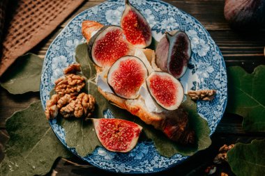 Camembert peynirli kruvasan ve incir dilimli tabak. Brie, sağlıklı sulu organik incir. Aperatif kahvaltı seti. Mevsimlik meyveler. Yüksek kalite fotoğraf