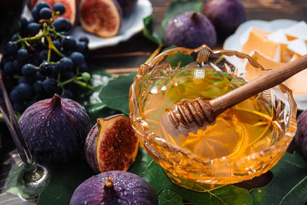 Peynir tabağıyla peynirli peynir, sağlıklı organik incir, bal ve üzüm. Kırmızı şarap kadehi, aperatif seti. Mevsimlik meyveler. Yüksek kalite fotoğraf