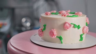 Pikapta harika bir kremalı pasta var. Narin pembe çiçeklerle süslenmiş, beyaz kremalı yeşil yapraklar. Fırın, kutlama, düğün, pasta konsepti. Yüksek kalite 