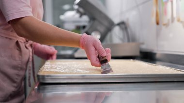 Mutfakta çalışan şekerci kadın. Badem hamuru pürüzsüz, ipeksi dokuya yayılıyor. Hassas hamur işleri - badem kurabiyeleri, tartlar, glütensiz fırınlar. 