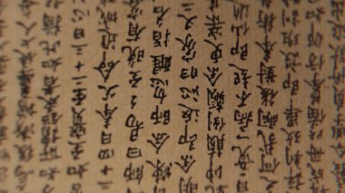 Geleneksel Çince karakterli eski el yazmasının makro görüntüsü. Eskimiş kağıt, siyah mürekkep, karmaşık el yazısı. Doğu mirası, bilgi, antik edebiyat. 