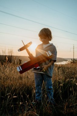 Gülümseyen, 5 yaşındaki anaokulu çocuğu tahta, eski model uçak oyuncaklarıyla oynuyor, gelecekteki mesleki ilgilerini keşfediyor, hayalperest çocuk uçuyor, seyahat ediyor. Yüksek kalite fotoğraf