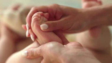 Yeni doğan bebeğin rahatlatıcı masajı için hassas bir yaklaşım. Yumuşak anne elleri yumuşak bebek teninin üzerinde süzülür. Rahatlama, sağlıklı gelişme, duygusal bağ. Yüksek kalite 4k görüntü
