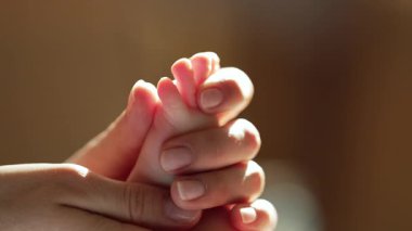 Yeni doğan bebeğin rahatlatıcı masajı için hassas bir yaklaşım. Yumuşak anne elleri yumuşak bebek teninin üzerinde süzülür. Rahatlama, sağlıklı gelişme, duygusal bağ. Yüksek kalite 4k görüntü