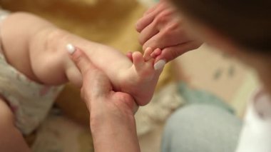 Yeni doğan bebeğin rahatlatıcı masajı için hassas bir yaklaşım. Yumuşak anne elleri yumuşak bebek teninin üzerinde süzülür. Rahatlama, sağlıklı gelişme, duygusal bağ. Yüksek kalite 4k görüntü