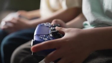 Oyuncuların Elleri, oyun konsoluyla çevrimiçi video oyunu oynuyor. Genç çocuklar düğmelere basıyor, joypad kumandası, en yeni kablosuz oyun sahası kullanıyor. Hobi, e-spor. 4k görüntü