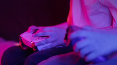 Oyuncuların Elleri, oyun konsoluyla çevrimiçi video oyunu oynuyor. Genç çocuklar düğmelere basıyor, joypad kumandası, en yeni kablosuz oyun sahası kullanıyor. Hobi, e-spor. 4k görüntü