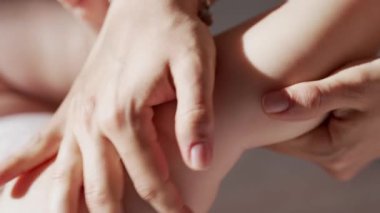 Yeni doğan bebeğin rahatlatıcı masajı için hassas bir yaklaşım. Yumuşak anne elleri yumuşak bebek teninin üzerinde süzülür. Rahatlama, sağlıklı gelişme, duygusal bağ. Yüksek kalite 4k görüntü