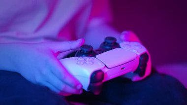 Oyuncuların Elleri, oyun konsoluyla çevrimiçi video oyunu oynuyor. Genç çocuklar düğmelere basıyor, joypad kumandası, en yeni kablosuz oyun sahası kullanıyor. Hobi, e-spor. 4k görüntü