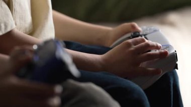 Oyuncuların Elleri, oyun konsoluyla çevrimiçi video oyunu oynuyor. Genç çocuklar düğmelere basıyor, joypad kumandası, en yeni kablosuz oyun sahası kullanıyor. Hobi, e-spor. 4k görüntü