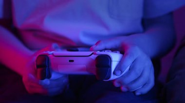 Oyuncuların Elleri, oyun konsoluyla çevrimiçi video oyunu oynuyor. Genç çocuklar düğmelere basıyor, joypad kumandası, en yeni kablosuz oyun sahası kullanıyor. Hobi, e-spor. 4k görüntü