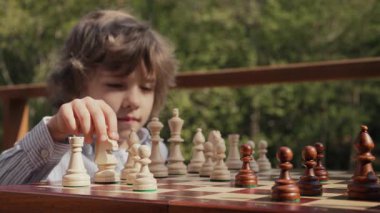 Tahta zeka oyunu oynayan öğrenci. Tahta satranç. Küçük çocuk at gibi hareket ediyor. Spor, başarı stratejisi kavramı