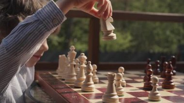 Tahta zeka oyunu oynayan öğrenci. Tahta satranç. Küçük çocuk at gibi hareket ediyor. Spor, başarı stratejisi kavramı