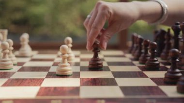 Kadın satranç maçında piyon yakalıyor. Tahta istihbarat oyunu oynayan kadın oyuncu. Kurul stratejisi, başarı işi, eski vintage parçalar