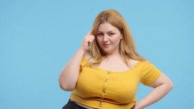 Akıllı Artı Boyutlu Kadın Hareketi Gösteriyor. Vücut pozitifliği olan öğrenci mavi kameraya bakıyor. Akıllıca düşünen biri. Yüksek kalite 4k