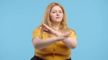 Hayır, asla, kavisli ciddi bir kadın el işaretini keserek hoşlanmaz ve reddeder. Onaylamayan şirin bir kız, inkar işareti, mavi stüdyo geçmişi. Yüksek kalite 4k görüntü