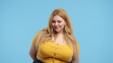 Güzel ve kilolu bir kadın el işaretini onaylar, tamam mı? Mutlu kıvrımlı kız, doğru seçim, harika bir anlaşma, mavi arka plan. Pozitif kadın model kameraya gülümser, onay, güven konsepti. 4k kalite