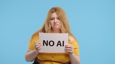 Mavi duvarda duran kıvrımlı kadın, elinde yapay zekaya hayır işareti var. Üzücü özgüven ifadesi, görsel protesto ya da görüş bildirimi Yüksek kalite 4K görüntü