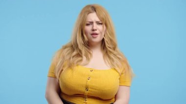 Ciddi vücut pozitifliği olan, kafa işareti olmadan onaylamayan, onaylanmayacak şekilde başını sallayan bir kadın. Reddetmek, reddetmek, anlaşmazlık, mavi arka planda güzel bir bayanın portresi. Yüksek kalite 4k görüntü