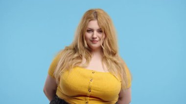 Artı boyunda bir kadın evet sinyali veriyor, başını sallıyor, onaylıyor. Mavi Stüdyo olumlu. Olumlu gülümseyen Amerikalı kız, vücut dili. Doğru mükemmel seçim, harika bir anlaşma. Yüksek kalite 4k görüntü