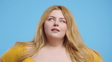 Ayrıca iri yapılı, sinirli, sinirli, sarışın kadın. Hayır, unuttum. Kederli Kız, Pişmanlık, Mavi arka planda Başarısızlık. Yüksek kalite 4k