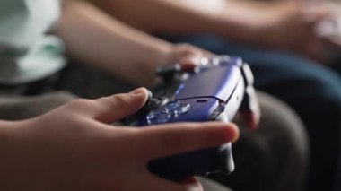 Oyuncuların Elleri, oyun konsoluyla çevrimiçi video oyunu oynuyor. Genç çocuklar düğmelere basıyor, joypad kumandası, en yeni kablosuz oyun sahası kullanıyor. Hobi, e-spor. 4k görüntü