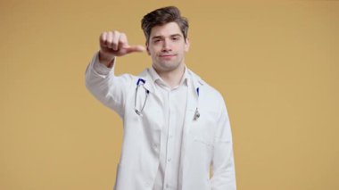 Mutsuz doktor portresi beyaz önlüklü adam sevmeme belirtileriyle kınanıyor. Olgun doktor, sarı stüdyo arka planında olumlu bir hareket göstererek memnuniyetsizliğini dile getiriyor..