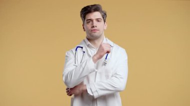 Beyaz önlüklü genç erkek doktor kameraya empatik bir ifadeyle bakıyor, hastayı dinliyor. Stüdyo fotoğraflarında tıbbi uzmanlar destek, ilgi ve ilgi gösteriyor. Yüksek kalite 4k görüntü