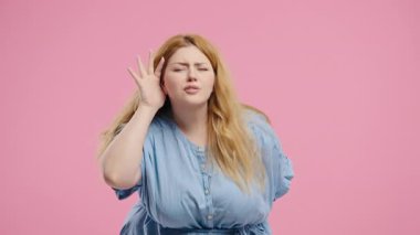 Genç bir kadın doğrudan kulak yönelten bir hareketle duyma sorunu ya da kafa karışıklığı gösteriyor. Ses sorunları, dikkat ipuçları, iletişim eksikliği, sesle ilgili görseller için mükemmel.