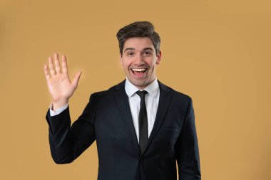 Dost canlısı Amerikalı Olgun 30 'lu yaşlardaki iş adamı El sallıyor. Bej stüdyoya selamlar. Yüksek kalite