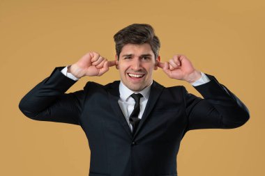 Takım elbiseli adam, gürültüyü ya da istenmeyen bilgiyi engelleyerek hayal kırıklığına uğruyor. Stres, aşırı yükleme, çatışma, işyeri anlaşmazlığı, iş bağlamında görüşlerin reddedilmesi.