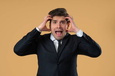 Şok olmuş bir iş adamı bir şeyden korkuyor ve bej arka planda korku dolu büyük gözlerle kameraya bakıyor. Fobi, sorun, panik konsepti. Yüksek kalite