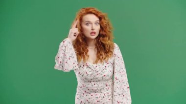 Kıvırcık kızıl saçlı kadın model kafasına dokunarak odaklanma hareketi yapıyor. Zekice bir fikir. Planlama, strateji, mantık, farkındalık, öz yansıma