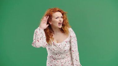 Doğal kızıl bukleleri olan genç bir kadın, işitme sorunu ya da kulak hizasıyla ilgili kafa karışıklığına işaret ediyor. Ses sorunları, dikkat ipuçları, iletişim eksikliği, sesle ilgili görseller için mükemmel.