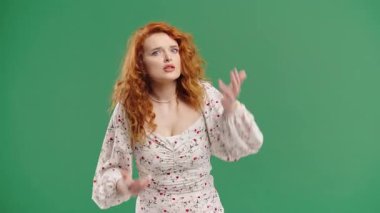 Kızgın kadın kameraya anlamlı bir yüzle bağırıyor, hayal kırıklığı içinde elini kaldırıyor.