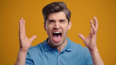 Mavili sinirli adam şok olmuş bir ifadeyle kameraya bağırıyor. Baskı altındaki adam kötü habere, iş başarısızlığına ya da ofisteki stresli duruma tepki veriyor..