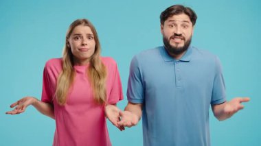 Karmaşık ifadelerle omuzlarını kaldıran erkek ve kadın, ne yapacaklarını bilmediklerini gösteriyorlar. Karışıklık, tereddüt, karar verme ya da belirsiz durumlar. Yüksek kalite 4k