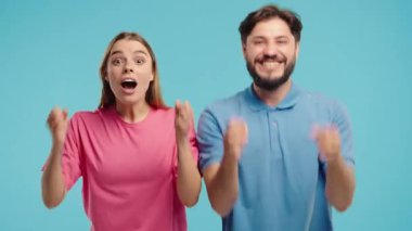 Kadın ve erkek kameraya gülümserken zaferle yumruklarını kaldırır. Başarı, çift kutlaması, motivasyon, başarı veya duygusal tepki içeriği