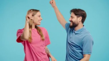 Komik, güzel bir kadın ve erkek. Mutlu bir çift. Eğleniyor, müzik dinliyor, gülümsüyor, mavi stüdyo arka planında dans ediyor. Müzik, dans konsepti