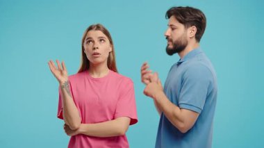 Genç çift, erkek konuşuyor ama ilgisiz kadın alaycı el işaretleriyle tepki veriyor. Mizah, ilişki dinamiği, fikir ayrılığı veya içerikte alay konusu olmak için idealdir. Yüksek kalite 4k