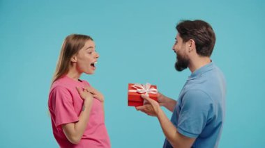 Mavi stüdyo geçmişi olan genç bir Amerikalı çift. Beyaz sakallı adam, karısı ya da kız arkadaşına selam verir. Doğum günü, kutlama, sürpriz, yıldönümü konsepti. Yüksek kalite 4k görüntü