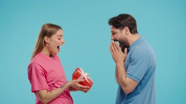 Mavi stüdyo geçmişi olan genç bir Amerikalı çift. Beyaz kadın kocasına ya da erkek arkadaşına selam verir. Doğum günü, kutlama, sürpriz, yıldönümü konsepti. Yüksek kalite 4k görüntü