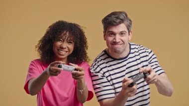 Oyuncular çeşitli çiftler konsol TV 'de oyun oynuyorlar. Oyun kumandalı, ırklar arası kadın ve erkek kazanıyor. Düğmelere basar, en yeni kablosuz oyun sahası. Hobi, e-spor. Yüksek kalite 4k görüntü