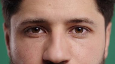 Yarı yüz, yakışıklı olgun bir adamın kaşları, doğal güzellik. 30 'lu yaşlarda Avrupalı görünümlü bir adam kameraya bakıyor. Kapalı koyu kahverengi gözler. Yüksek kalite 4k görüntü