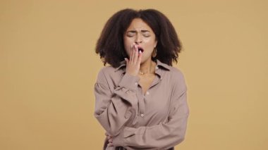 Yorgun, melez bir kadın eli kolu bağlı bir şekilde esniyor. Yorgunluktan ölüyor. Yorgunluk, stres, uzun bir gün, modern yaşam tarzı temalarında gerçek hayat anları. Yüksek kalite 4k görüntü