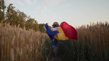 Küçük çocuk, rüzgarda dalgalanan Romanya bayrağını sallayarak koşuyor. Romanyalılar derin tarım mirası, vatansever ruh, toprak, yeni nesil. Çiftçilik, Doğu Avrupa kimliği, bağımsızlık